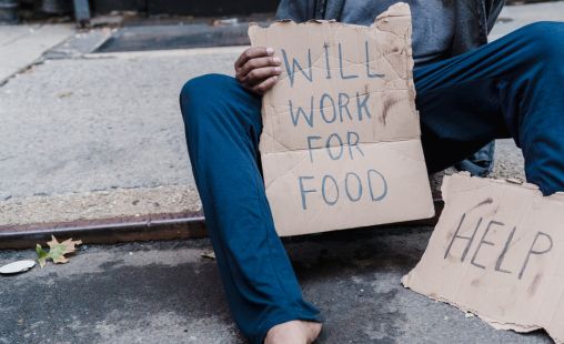 person holding will work for food sign